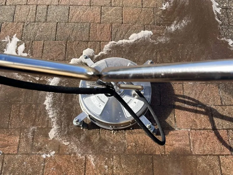 Rotary surface cleaner pressure washing a block paved driveway